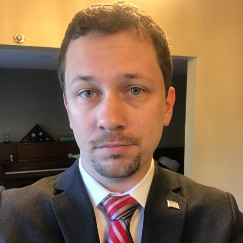 Portrait of Ryan Gentry wearing a suit and tie.